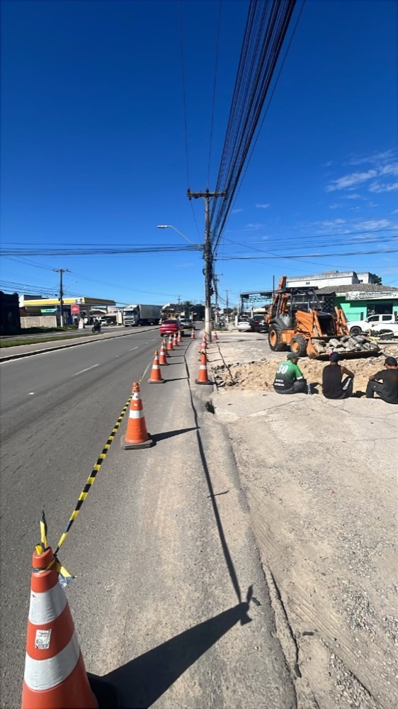 Escavação na via com retroescavadeira e cones na obra M3VOLT em 15/09/2026